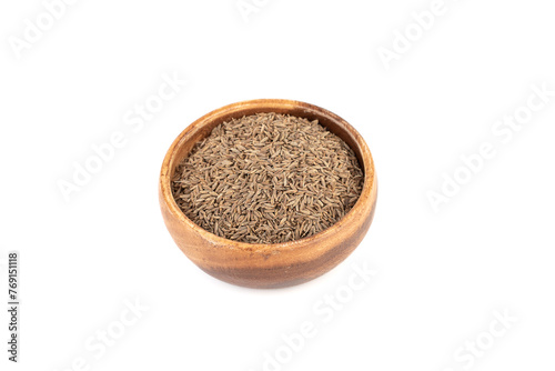 Aromatic cumin seeds in a wooden bowl on a white background.