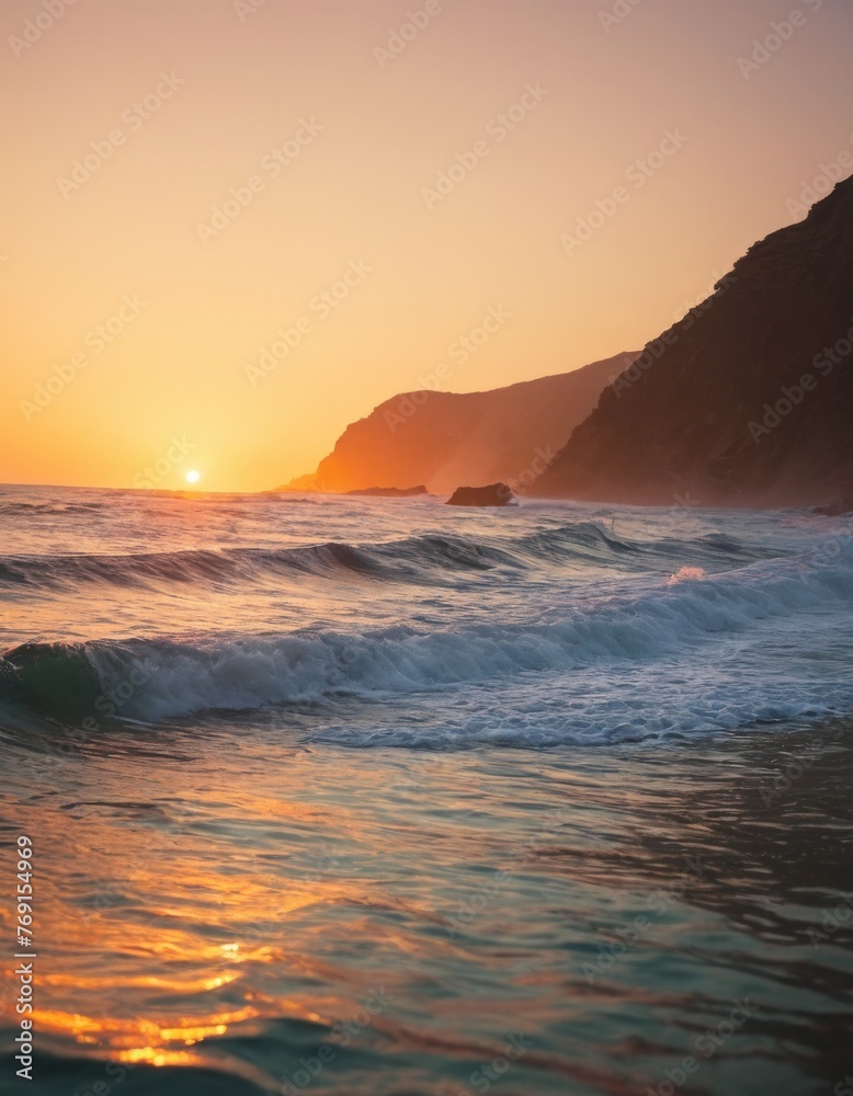 Waves gently break on the shore under a warm sunset, with the sun dipping behind a silhouette of a cliff by the sea.