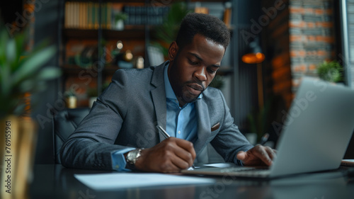 a person in a grey suit and blue shirt, seated at a dark-colored desk. He is writing on a piece of paper,generative ai