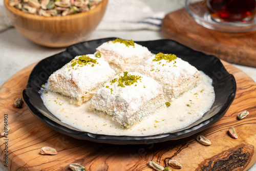 Baklava with white chocolate and milk. Cold baklava with chocolate on a wooden serving board. Famous dishes of Turkish cuisine