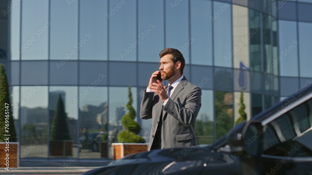 Rich boss talking cellphone getting in car at business area. Businessman calling Rich boss talking cellphone getting in car at business area. Businessman calling