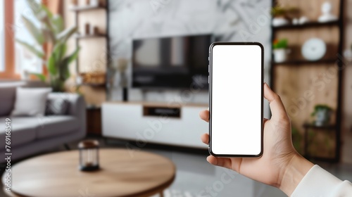 a person holding a phone in their hand in a living room with a television in the background