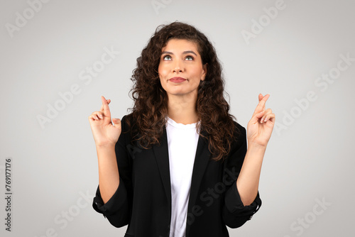 Quadro su tela Hopeful woman entrepreneur crossing fingers
