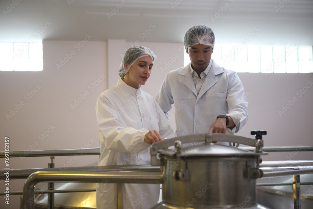 Winemaker working in modern large winery factory drink industry and testing wine in a wine factory warehouse Winemaker working in modern large winery factory drink industry and testing wine in a wine factory warehouse