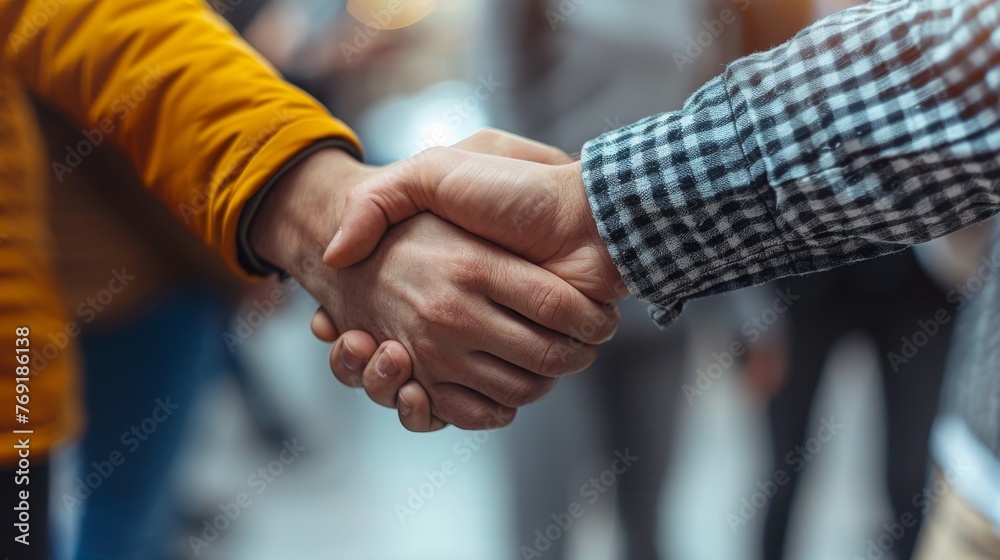 Macro shot of startup founders shaking hands in agreement, symbolizing unity and determination in building their venture.
