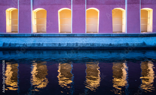 Illuminated pedestrian walkway along the Memminger Ach river in Memmingen and the reflection of the architecture in the water photo