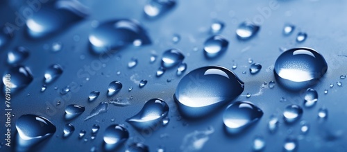 A close up of water droplets on a vivid blue surface, showcasing the beauty and purity of liquid moisture, resembling a drizzle of electric blue dew