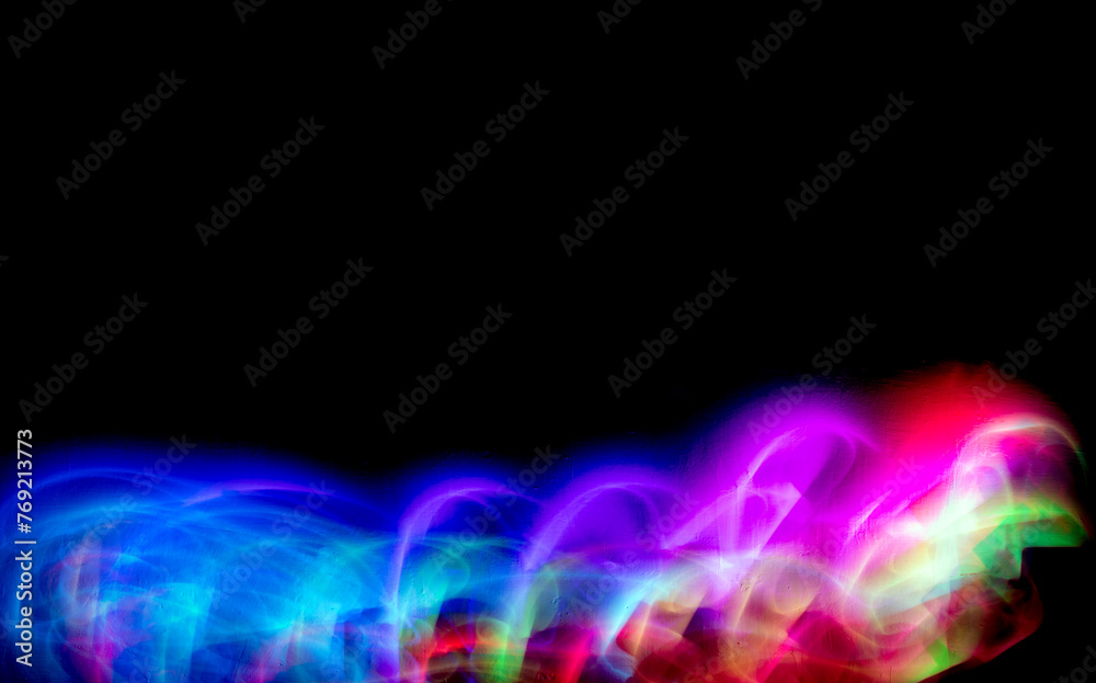 Abstract colorful irregular lines on black background and wall texture. Long exposure. Light painting photography.