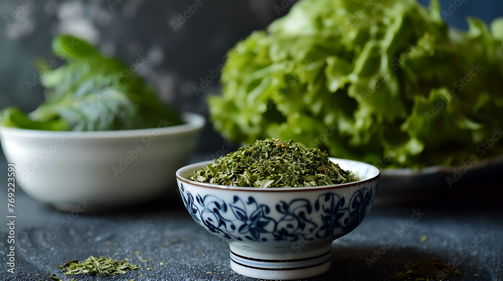 a small bowl of dried, crumbled green herbs in the foreground. a small bowl of dried, crumbled green herbs in the foreground.