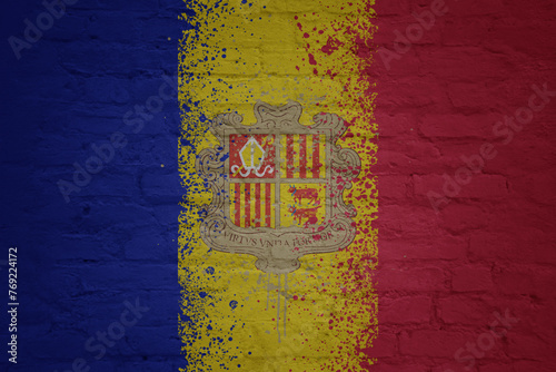 colorful painted big national flag of andorra on a massive brick wall
