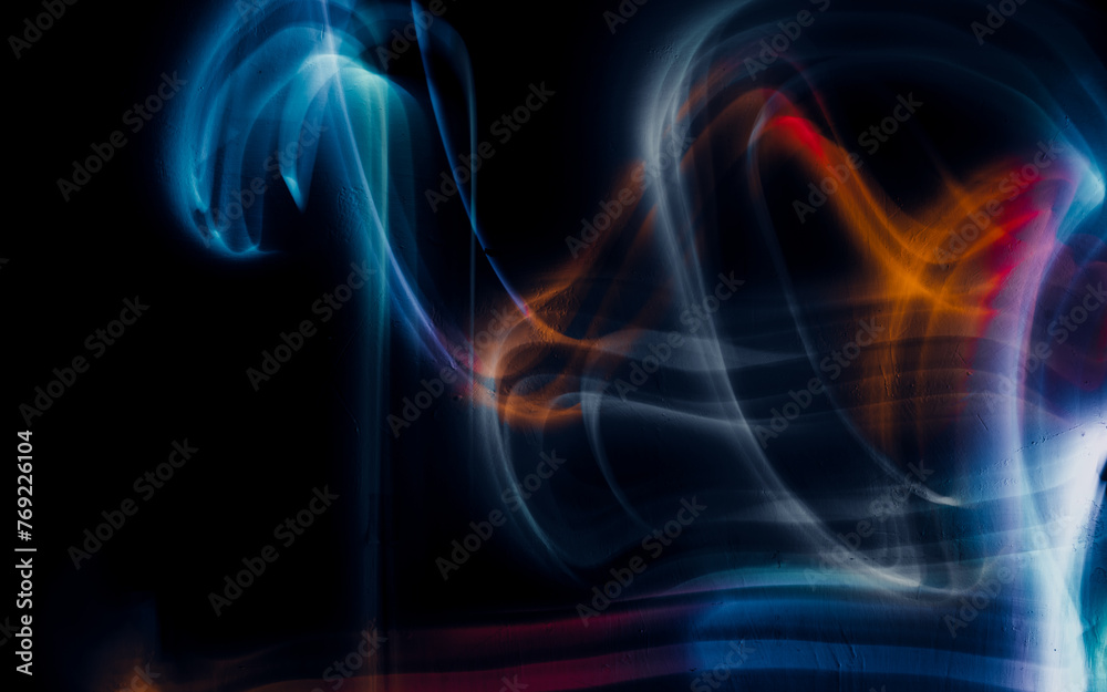 Obraz premium Abstract colorful irregular lines on black background and wall texture. Long exposure. Light painting photography.