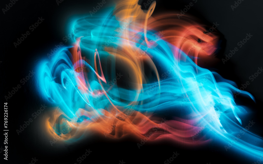 Fototapeta premium Abstract colorful irregular lines on black background and wall texture. Long exposure. Light painting photography.