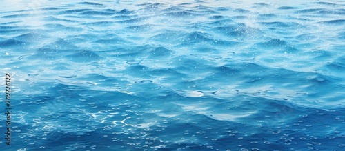 Close-up view of the deep blue ocean with gentle waves rolling towards the shore under the clear sky