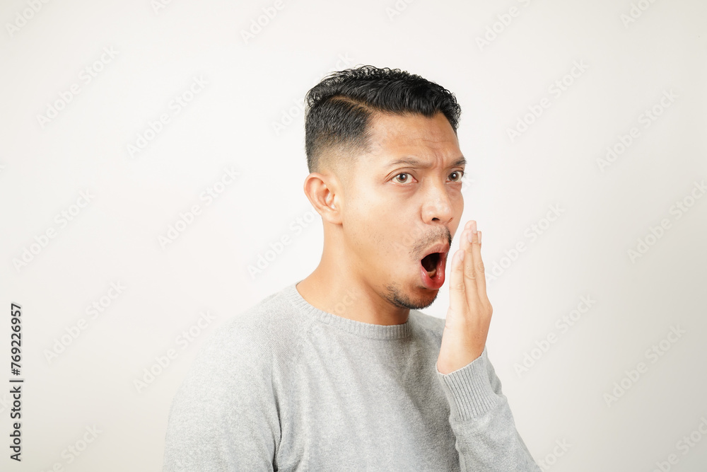 Funny facial expression bad breath with hand covering mouth of Asian man Funny facial expression bad breath with hand covering mouth of Asian man