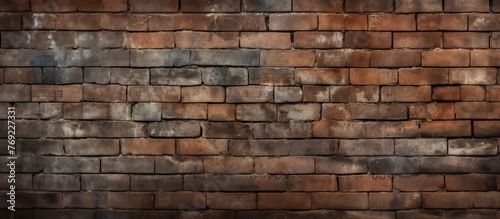A detailed closeup of a brick wall showcasing the building material  brickwork  composite material  pattern  mortar  and stone wall texture with grass and soil visible in between the bricks