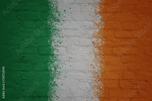 colorful painted big national flag of ireland on a massive brick wall
