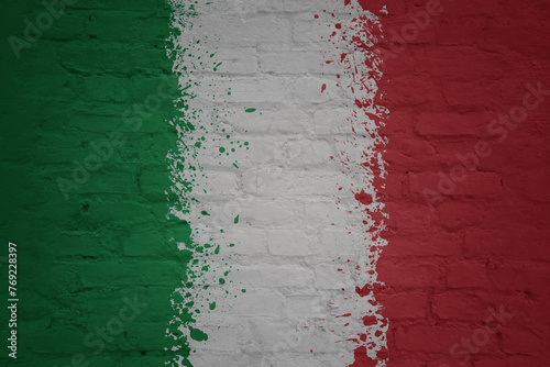 colorful painted big national flag of italy on a massive brick wall