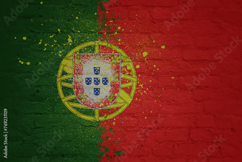 colorful painted big national flag of portugal on a massive brick wall