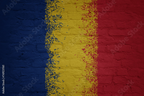 colorful painted big national flag of romania on a massive brick wall