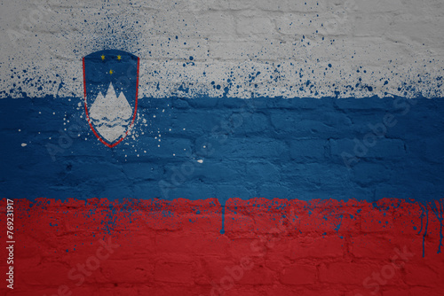 colorful painted big national flag of slovenia on a massive brick wall