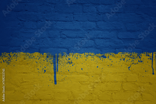 colorful painted big national flag of ukraine on a massive brick wall