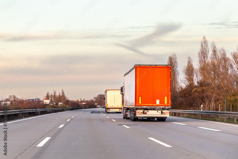 trucks at the highway in sunset sky