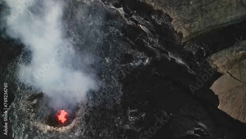 Erta Ale, Danakil Depression, Ethiopia. Top down aerial view of active volcano smoking and lava activity. Cinematic drone footage travelling above the smaller volcanic pit at sunset. photo