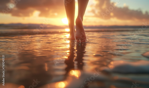 Woman walking on the beach by ocean at sunset. Close up to legs. Travel and vacation concept.