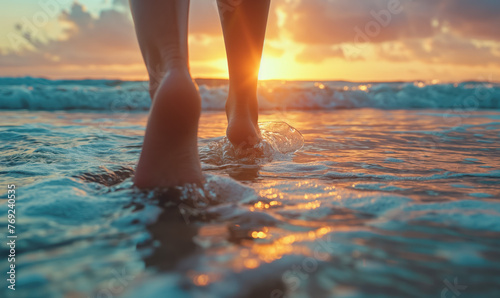 Woman walking on the beach by ocean at sunset. Close up to legs. Travel and vacation concept.