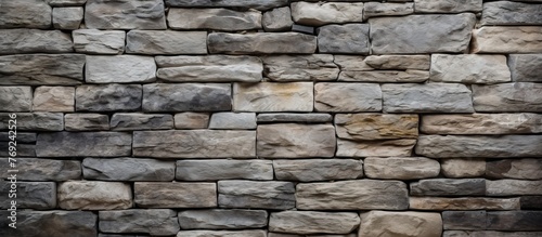 A detailed view of a propertys stone wall constructed with rectangular bricks  showcasing a beautiful pattern of composite material and cobblestone