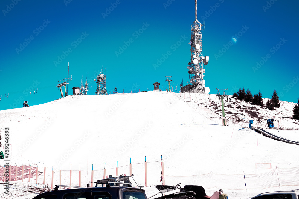 The ski lift under the moon. The top of Mottarone mountain (1491 meters above sea level) on a winter morning.  Ski lift and ski slope. Piedmont - Italy. - obrazy, fototapety, plakaty 