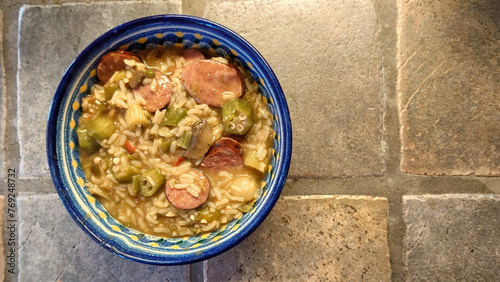 homemade Cajun sausage gumbo with rice, bell peppers, celery, okra, and onions in a spicy roux photo