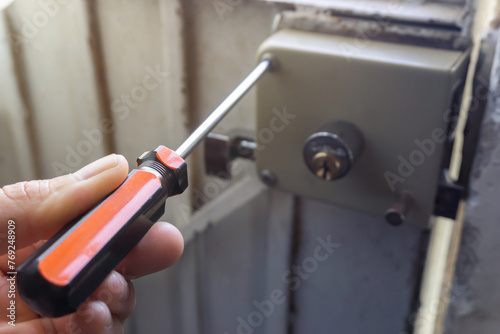 repairing the house lock with screwdriver, home repair concept