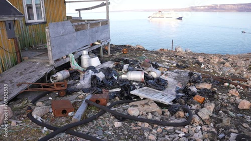 Cape Tobin, Greenland. Trash and Waste by Abandoned House and Coastline photo