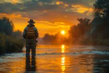 As the sun sets, a fisherman stands in gently flowing river waters, creating a poignant scene