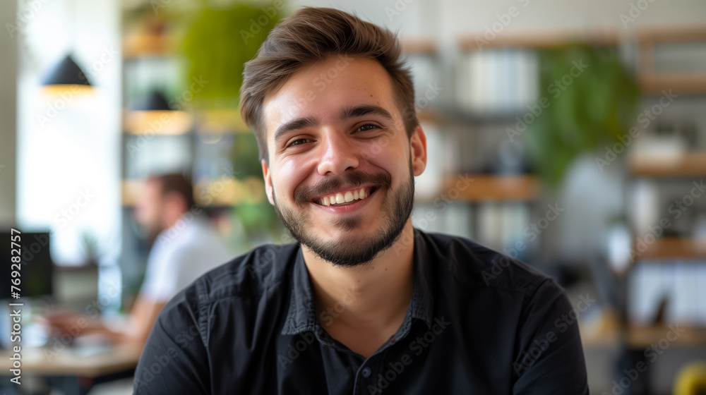 portrait of young employee wearing black shirt smiling looking at camera in modern office, job satisfaction concept, smiling person portrait portrait of young employee wearing black shirt smiling looking at camera in modern office, job satisfaction concept, smiling person portrait