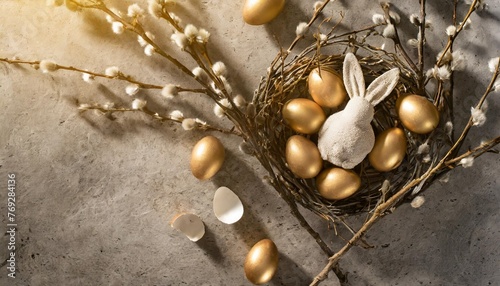 bunny and eggs nestled in branches on the concrete background top view