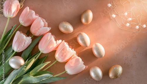 soft pink tulips and easter eggs flat lay on salmon background