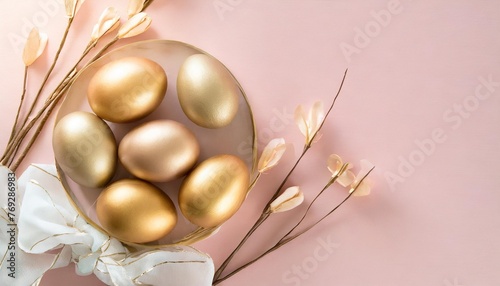 golden easter eggs on pastel pink background top view