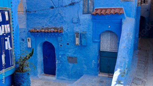 Blue doors in a blue wall along an alley in the medina in Chefchaouen, Morocco © Angela