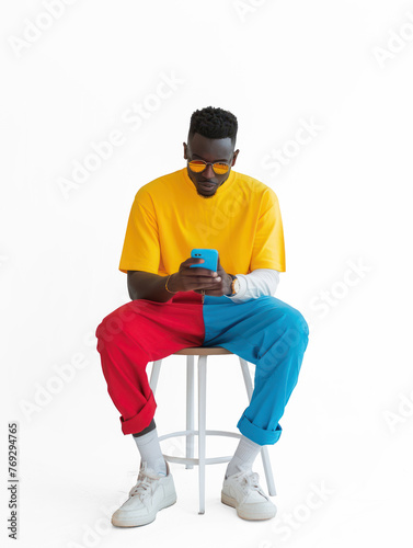 a man chatting to his phone siting on a chair on transparency background PNG  © Sim