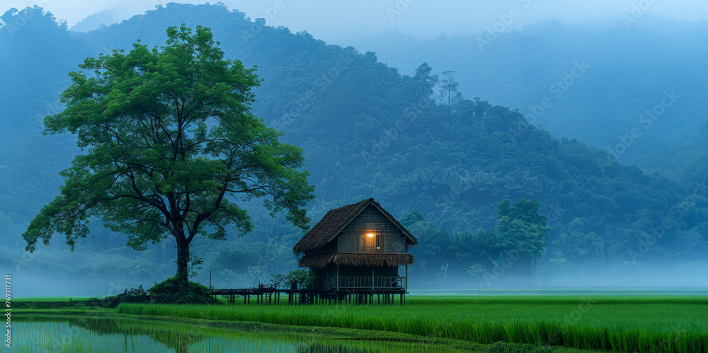 Fototapeta premium Traditional house in a serene rural landscape with mountains in the background