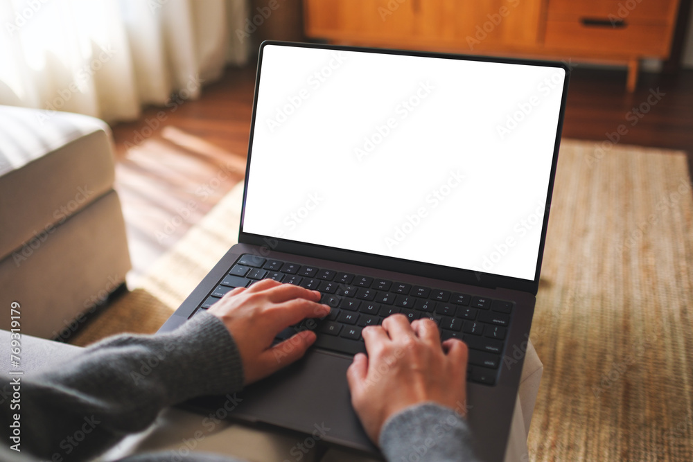 Mockup image of a woman working and typing on laptop computer with blank white desktop screen at home - obrazy, fototapety, plakaty 