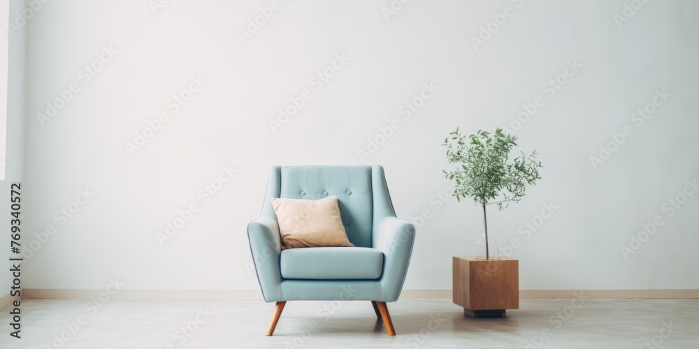 A blue chair with a white pillow sits in front of a potted plant