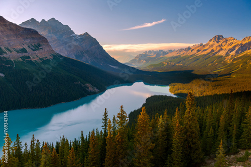 Beautiful sunset over Peyto Lake in Banff National Park in Canadian Rocky Mountains; picturesque mountain lake surrounded by majestic peaks and lush forest