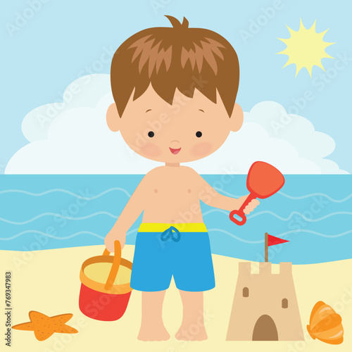 Toddler boy with sand bucket and scoop in hand on summer beach
