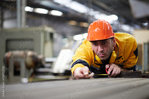 worker or technician using tape measure and measuring the length of the machine in the factory
