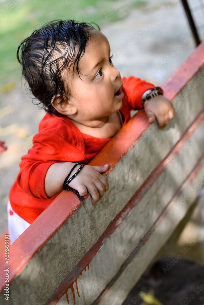 Obraz premium Smart Asian boy riding on swing in society park, happy boy play outdoors in summer, baby boy playing swing in the garden