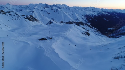 Early morning drone shot over snowy mountain alps. Picturesque view of alpine landscape in Italy. Aerial view over the Presena glaicer at dawn. Snow-capped landscape. photo