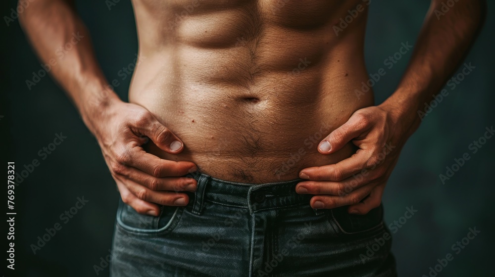 A man stands with his hands placed on his hips while looking ahead